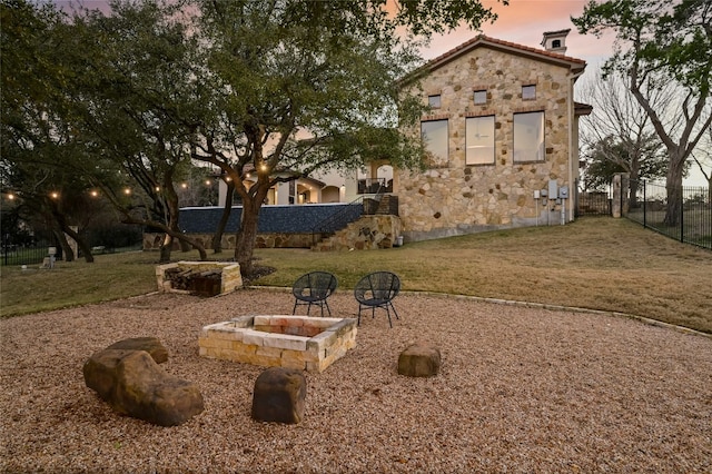 view of yard featuring an outdoor fire pit and fence