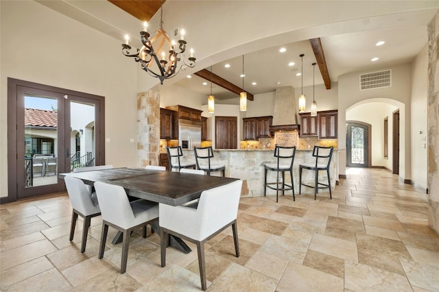 dining room featuring arched walkways, beam ceiling, visible vents, and stone tile floors