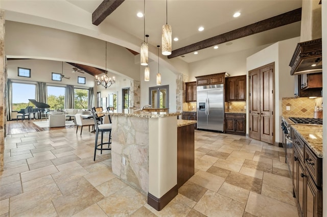 kitchen with hanging light fixtures, a spacious island, appliances with stainless steel finishes, and a kitchen breakfast bar