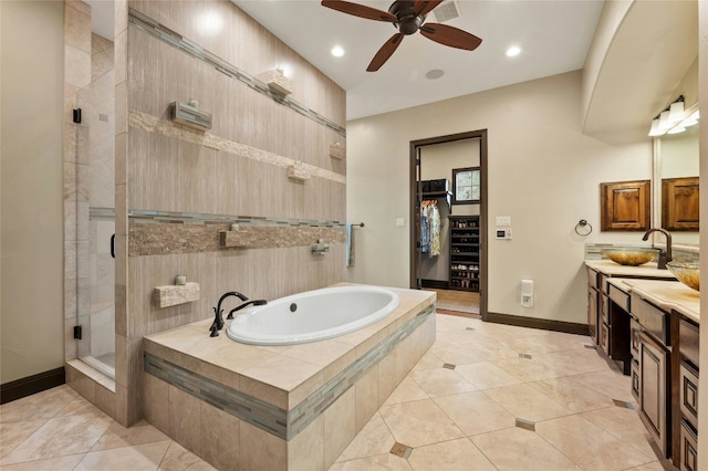 full bath with baseboards, tile patterned floors, a garden tub, a spacious closet, and a shower stall