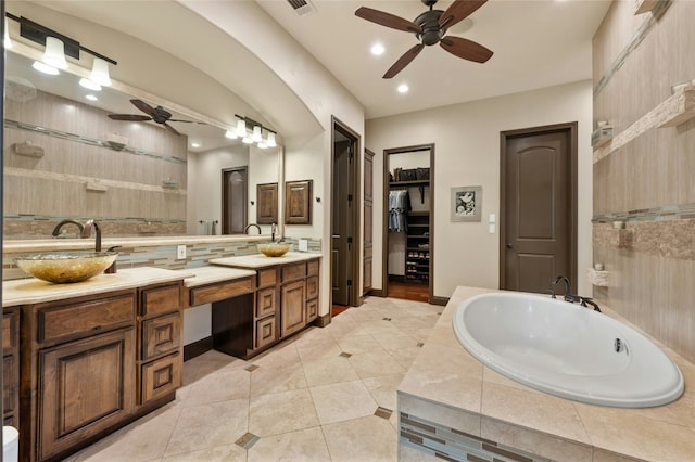 bathroom featuring a walk in closet, recessed lighting, tile patterned floors, vanity, and a bath