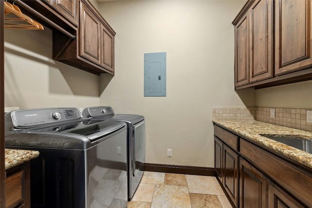 laundry area featuring washer and clothes dryer, baseboards, cabinet space, electric panel, and stone finish floor