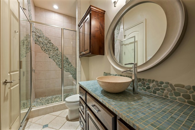 bathroom with toilet, a shower stall, tile patterned flooring, and vanity