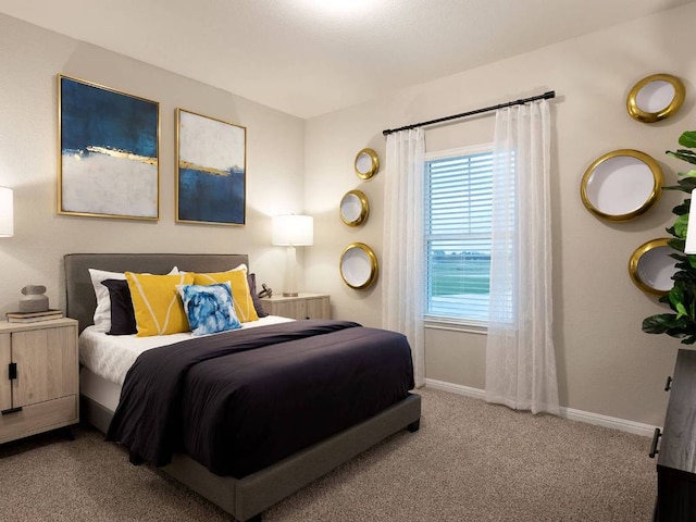 bedroom featuring light colored carpet and baseboards