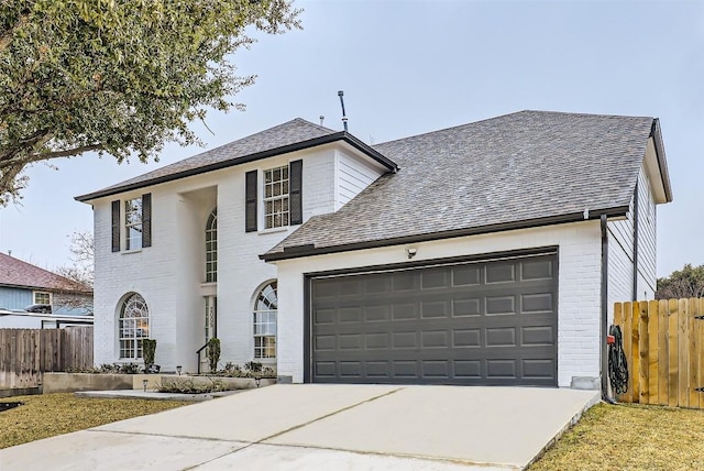 view of front facade featuring a garage, brick siding, fence, and driveway