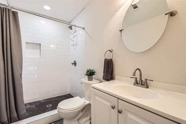 bathroom with a stall shower, visible vents, vanity, and toilet