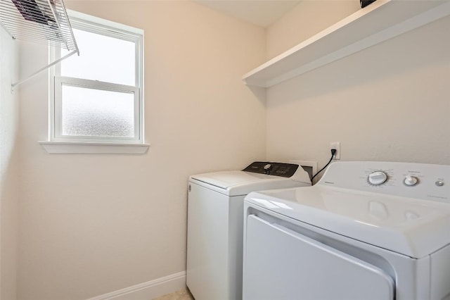 clothes washing area featuring laundry area, baseboards, and independent washer and dryer