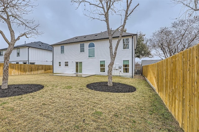 rear view of house with a fenced backyard, a yard, central AC unit, and a patio