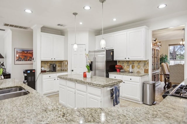 3304 Mulberry Creek Dr, Austin, TX 78732 - kitchen with stainless steel fridge, decorative backsplash, recessed lighting, light stone counters, and ornamental molding