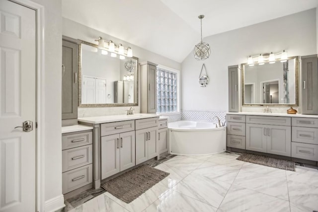 3304 Mulberry Creek Dr, Austin, TX 78732 - bathroom featuring marble finish flooring, two vanities, vaulted ceiling, and a bath