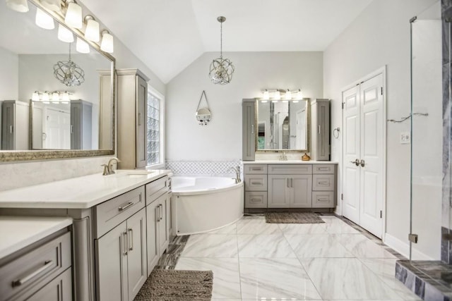 3304 Mulberry Creek Dr, Austin, TX 78732 - full bath with two vanities, marble finish floors, a bath, vaulted ceiling, and a chandelier