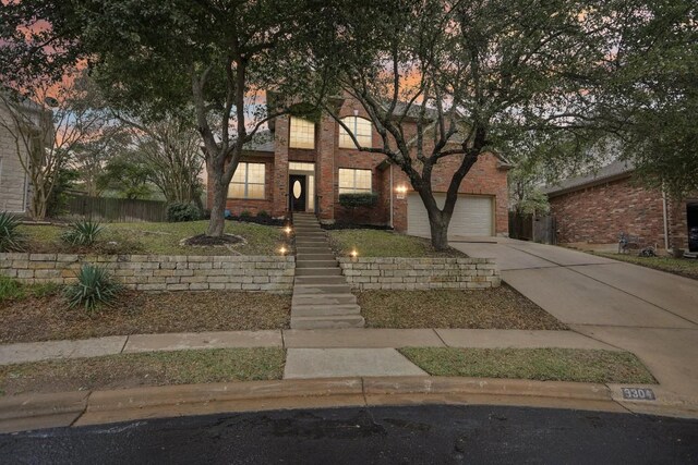3304 Mulberry Creek Dr, Austin, TX 78732 - view of front facade featuring driveway, brick siding, and an attached garage