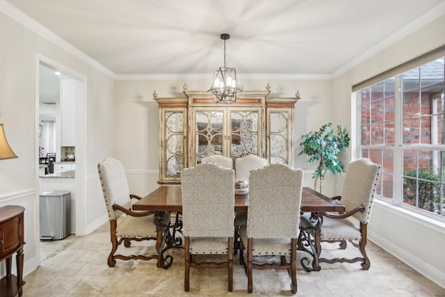 dining area with an inviting chandelier, baseboards, and crown molding