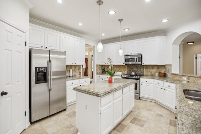 kitchen featuring hanging light fixtures, light stone countertops, white cabinetry, and stainless steel appliances