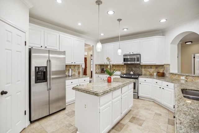 3304 Mulberry Creek Dr, Austin, TX 78732 - kitchen featuring appliances with stainless steel finishes, arched walkways, a center island, white cabinetry, and crown molding