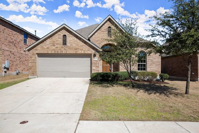 view of front facade with driveway, a garage, and brick siding