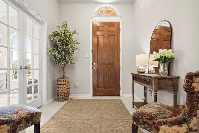 foyer with light tile patterned floors, french doors, and baseboards