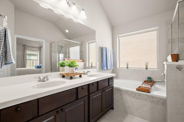 bathroom featuring connected bathroom, vaulted ceiling, a garden tub, and a sink