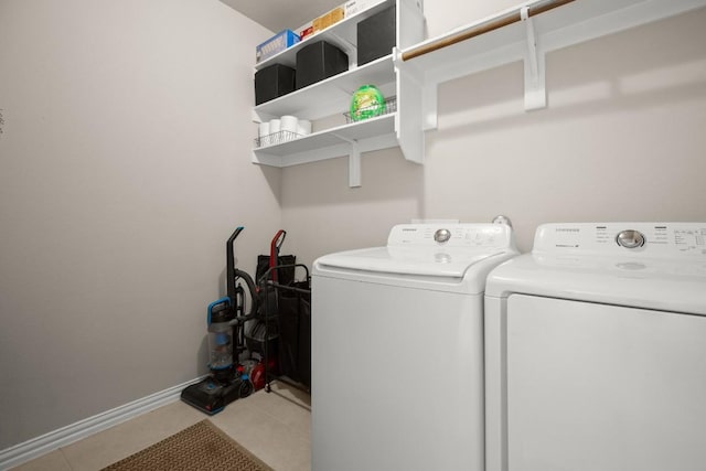 laundry area featuring tile patterned flooring, laundry area, baseboards, and separate washer and dryer