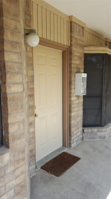 entrance to property featuring brick siding