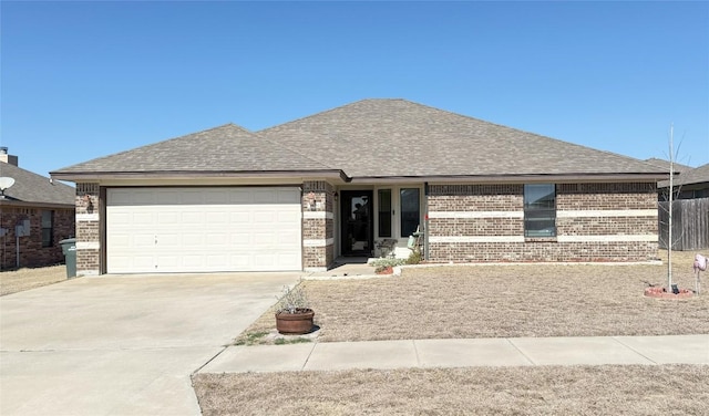 view of front of home featuring a garage, brick siding, driveway, and roof with shingles