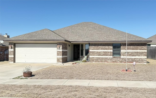 ranch-style house with a garage, brick siding, and a shingled roof