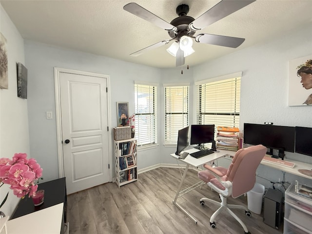 office with a textured ceiling, ceiling fan, light wood-style flooring, and baseboards