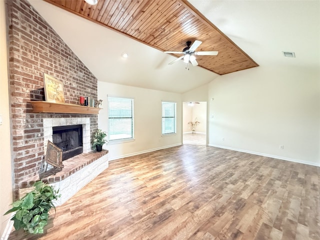 unfurnished living room featuring visible vents, lofted ceiling, wood finished floors, a fireplace, and a ceiling fan