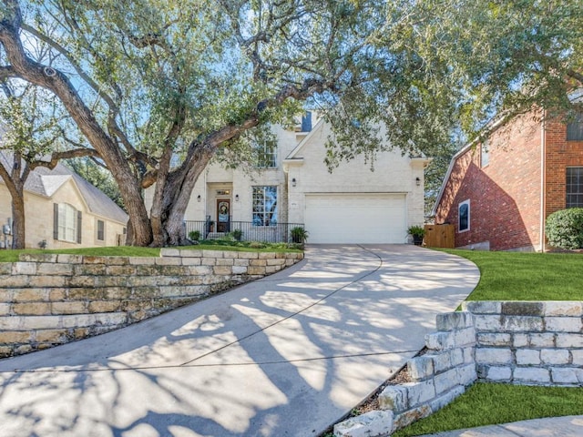 view of front of property featuring a garage, concrete driveway, and fence