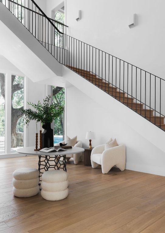 living area with a healthy amount of sunlight, a towering ceiling, and wood finished floors