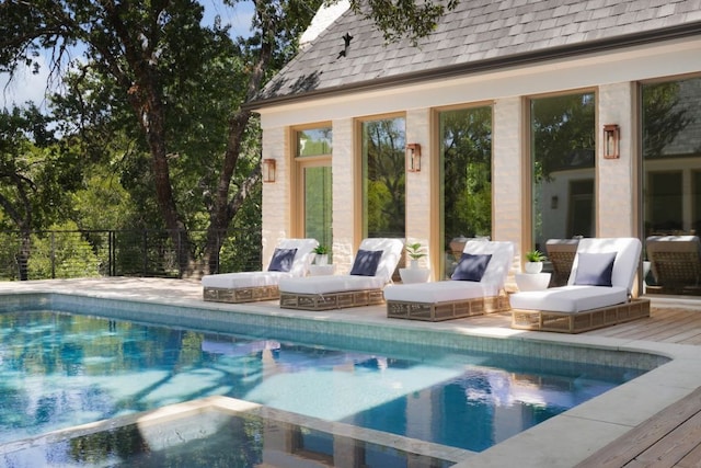 pool featuring a wooden deck and fence