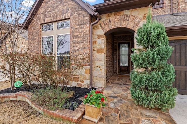 doorway to property featuring stone siding and brick siding