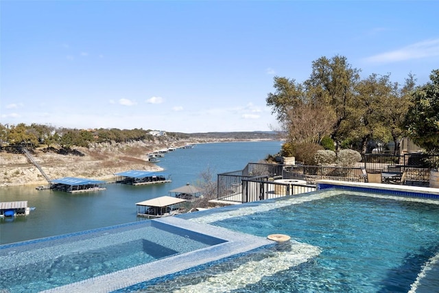 outdoor pool featuring a water view, fence, and a hot tub