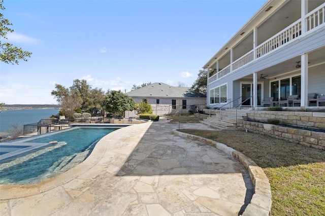 view of swimming pool featuring a fenced in pool, a patio area, a water view, and ceiling fan