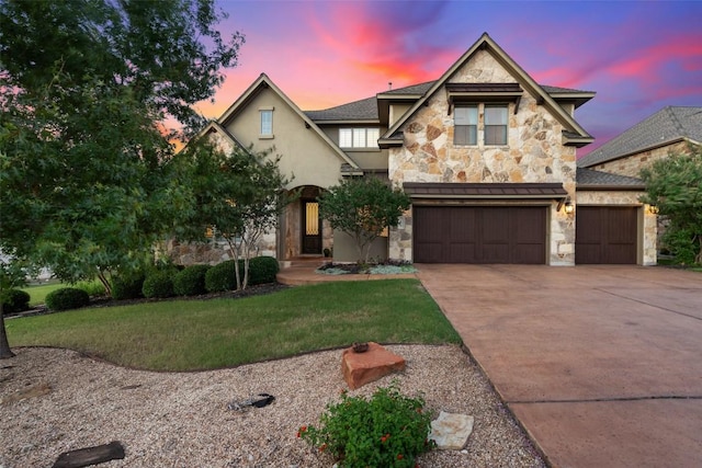 view of front of property featuring driveway, a front lawn, stone siding, and stucco siding