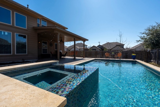 view of pool with a patio area, a pool with connected hot tub, a ceiling fan, and a fenced backyard