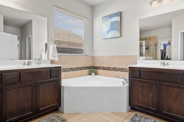 full bath with a sink, two vanities, tile patterned floors, a bath, and a shower stall