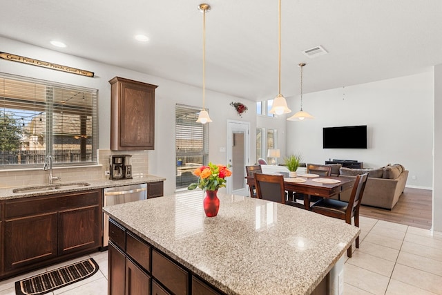 19900 Kite Wing Ter, Pflugerville, TX 78660 - kitchen with a sink, light tile patterned floors, hanging light fixtures, decorative backsplash, and dark brown cabinetry