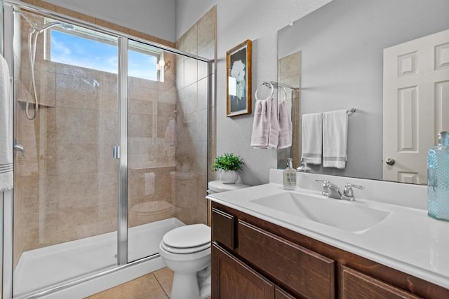 full bathroom with a stall shower, vanity, toilet, and tile patterned floors