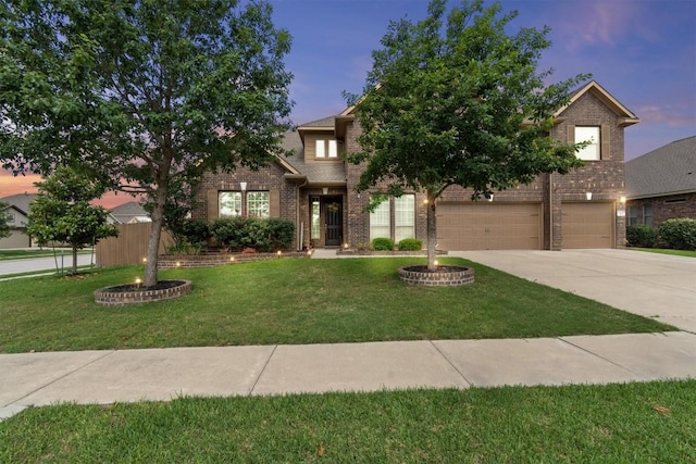 view of front facade with concrete driveway, a front lawn, brick siding, and an attached garage