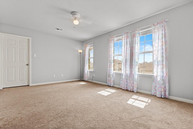 empty room featuring visible vents, baseboards, ceiling fan, and carpet floors
