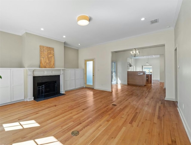 unfurnished living room with baseboards, visible vents, a tiled fireplace, crown molding, and light wood-style floors