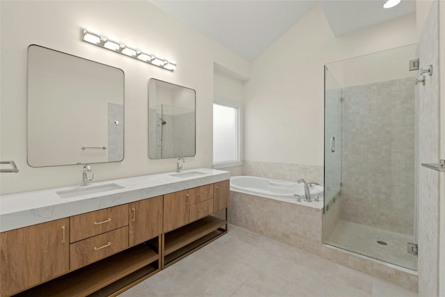 bathroom with double vanity, a garden tub, a sink, and tile patterned floors