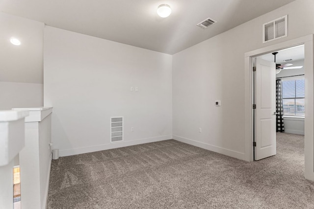 carpeted empty room featuring visible vents, ceiling fan, and baseboards