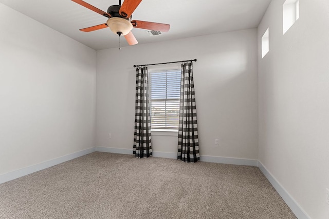 unfurnished room featuring baseboards, visible vents, a ceiling fan, and light colored carpet