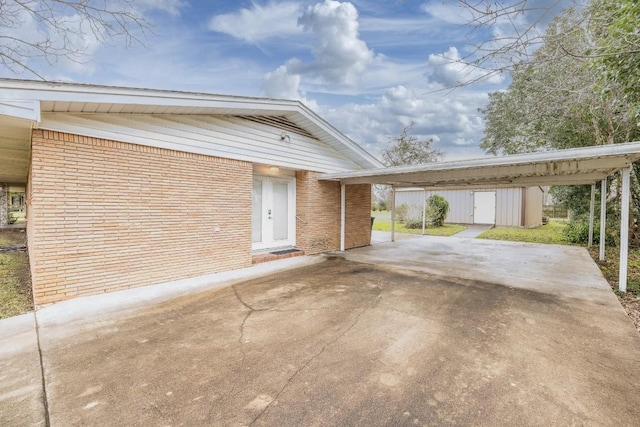 view of front of house with concrete driveway, brick siding, and an outdoor structure