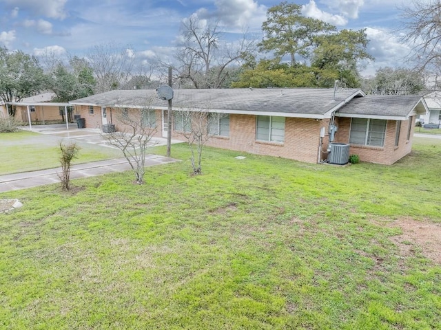 view of front of house with central AC unit, driveway, brick siding, and a front yard