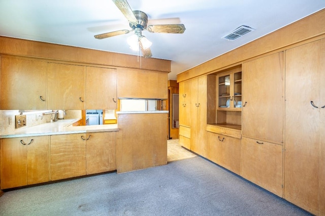 kitchen featuring light colored carpet, light countertops, visible vents, a sink, and ceiling fan