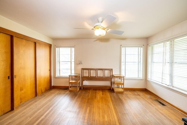 living area featuring light wood-style floors, visible vents, and baseboards