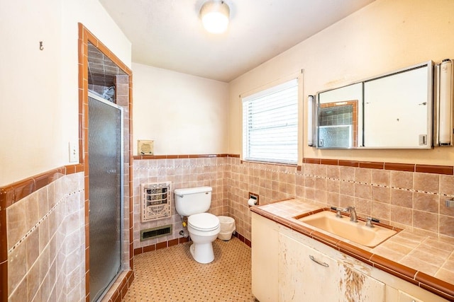 full bathroom featuring a stall shower, visible vents, wainscoting, heating unit, and tile walls